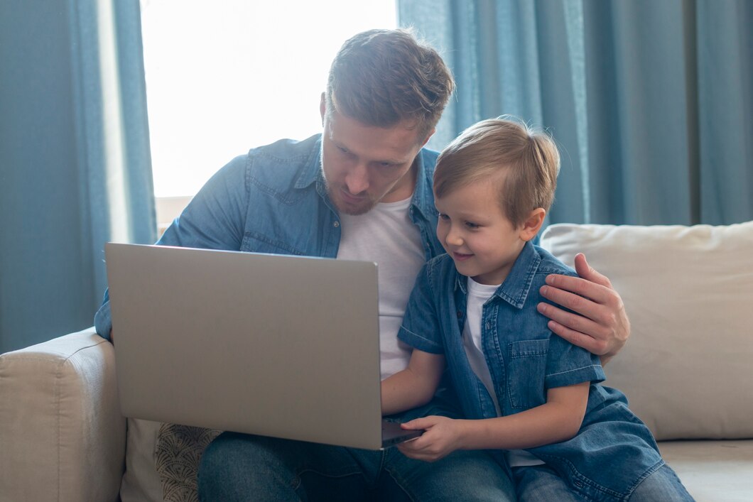 dia dos pais pai e filho olhando para laptop 23 2148511197