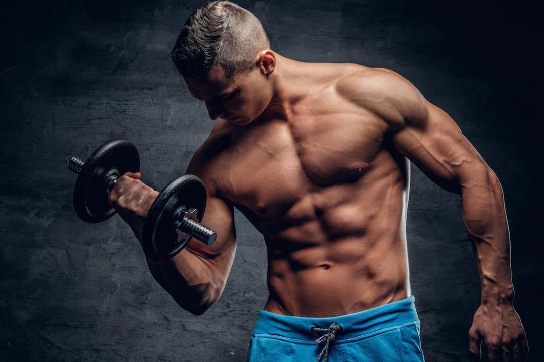 homem atletico sem camisa fazendo exercicios de biceps com um haltere em fundo cinza vinheta 613910 24