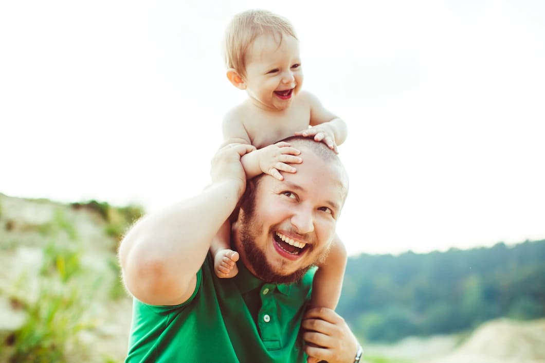 pai com camisa verde mantem filho pequeno no pescoco 1304 4881